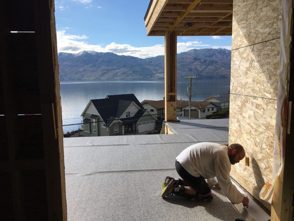 Man installing waterproof Vinyl decking during new home construction