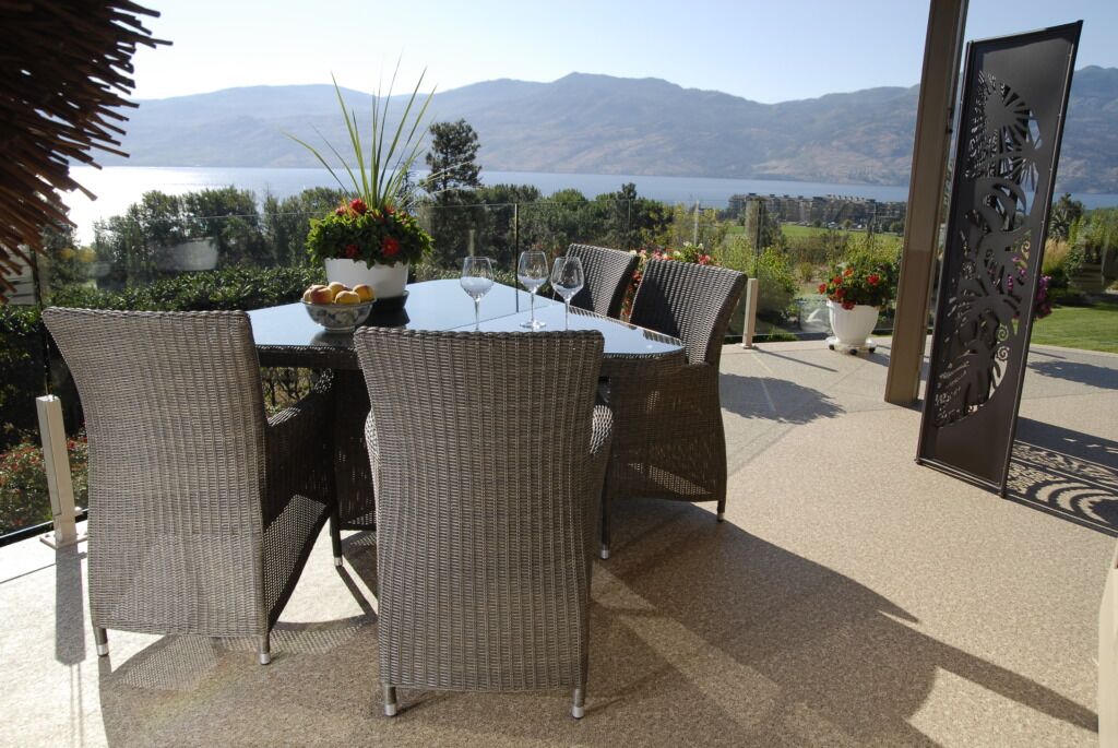 Patio deck and chairs with potted plants and s portable screen on a newly resurfaced vinyl deck.